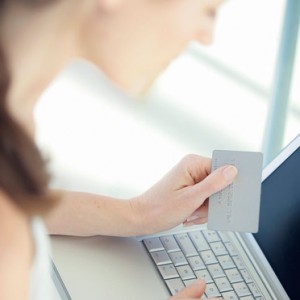Une femme devant son ordinateur avec une carte de crédit